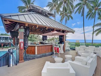 a bar with white furniture and a swimming pool at Beach Resort condo 921 in Miami Beach