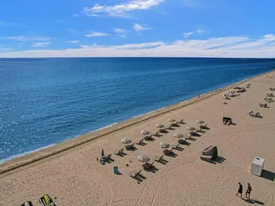 a beach with chairs and umbrellas and the ocean at Beach Resort condo 921 in Miami Beach