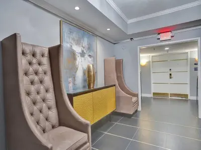 a hallway with chairs and a table and a painting at Beachfront Ocean View Condo Beach Service 520 in Miami Beach