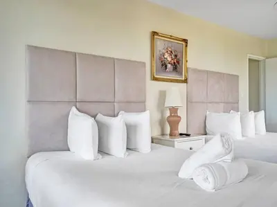 two beds with white pillows in a hotel room at Beachfront Ocean View Condo Beach Service 520 in Miami Beach
