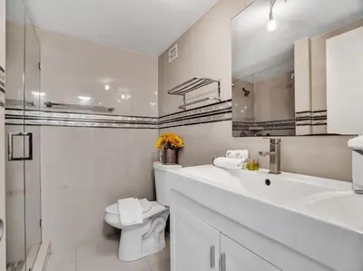 a white bathroom with a sink and a toilet at Amazing Ocean View Condo Beach Service 1111 in Miami Beach