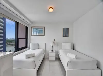 a white living room with two white couches and a window at Amazing Ocean View Condo Beach Service 1111 in Miami Beach