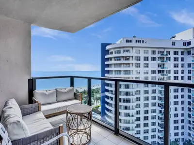 a balcony with two couches and a view of a building at High Floor Beachfront Condo Beach Service 1509 in Miami Beach