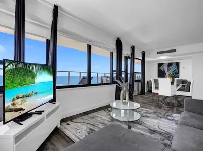 a living room with a large flat screen tv at Full ocean view Huge private terrace 1002 in Miami Beach
