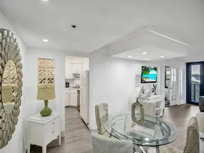 a living room with a glass table and a kitchen at Charming Ocean View Condo Beach Service 516 in Miami Beach
