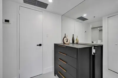 a black dresser in a room with white walls at Relax in Style 3BR 2BA Beach Condo in Oceanfront Resort Pools Gym Sauna 1507 in Miami Beach