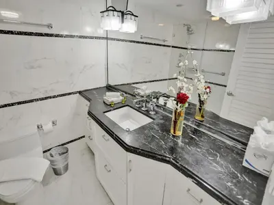 a white bathroom with a sink and a toilet at Ocean View Condo Beach Service and Pool 618 in Miami Beach