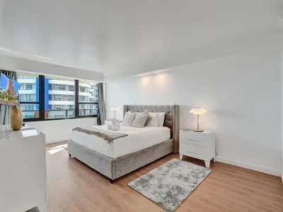 a white bedroom with a bed and a large window at Spacious Ocean View Condo Beach Service 803 in Miami Beach