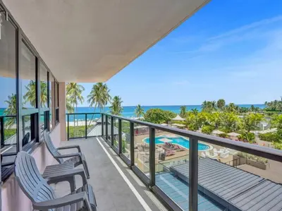 a balcony with two chairs and a view of the ocean at Luxury Full Ocean View Condo Resort Amenities 501 in Miami Beach