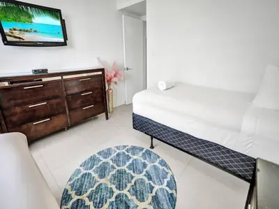 a bedroom with a bed and a dresser and a tv at Spacious Ocean View Condo Beach Service 509 in Miami Beach