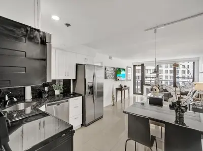 a kitchen with white cabinets and stainless steel appliances at Spacious Ocean View Condo Beach Service 509 in Miami Beach