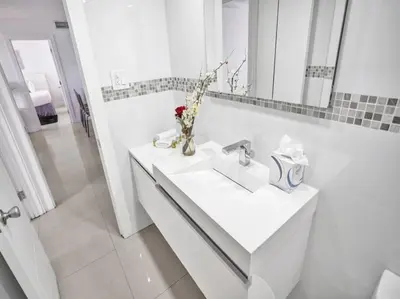 a white bathroom with a sink and a mirror at Spacious Ocean View Condo Beach Service 509 in Miami Beach