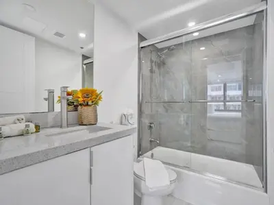 a bathroom with a toilet and a glass shower at Ocean View Retreat Beach Service 1603 in Miami Beach