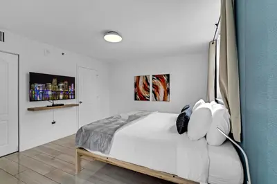 a bedroom with a large bed with white walls at LUX 2B/2B Brickell - Free Parking in Miami