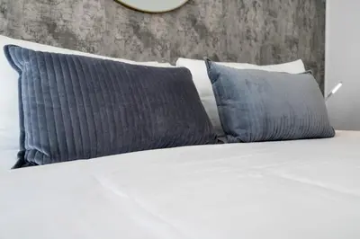 a bed with two blue pillows on top of it at LUX 2B/2B Brickell - Free Parking in Miami
