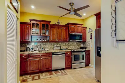 a kitchen with wooden cabinets and a ceiling fan at Go with the Flow in Hollywood