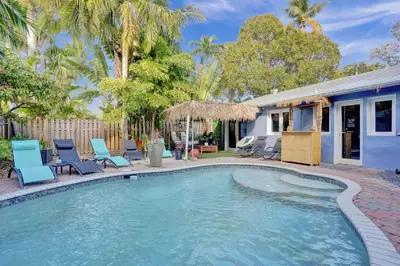 a swimming pool with chairs and a house at Kiki 1 - Men's Clothing optional Guest Houses in Fort Lauderdale
