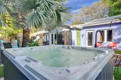 a large hot tub in a yard with a house at Kiki 1 - Men's Clothing optional Guest Houses in Fort Lauderdale