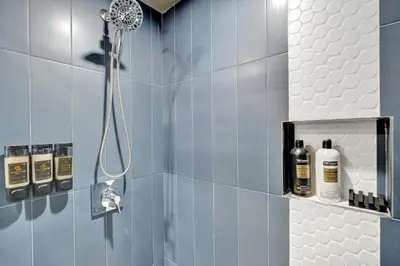 a shower in a bathroom with blue tiles at Kiki 2 - Men's Clothing optional Guest Houses in Fort Lauderdale