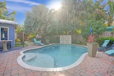 a small pool in a yard with chairs and trees at Kiki 2 - Men's Clothing optional Guest Houses in Fort Lauderdale