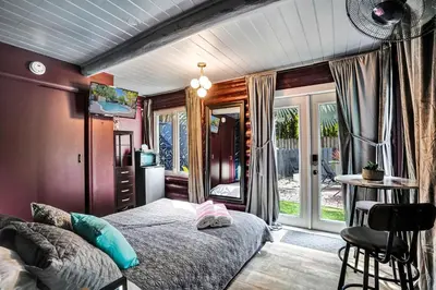 a bedroom with a bed and a table and a window at Kiki 3 - Men's Clothing optional Guest Houses in Fort Lauderdale