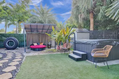 a backyard with two chairs and a bed and a fence at Kiki 3 - Men's Clothing optional Guest Houses in Fort Lauderdale