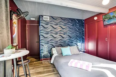 a small bedroom with a bed and a table at Kiki 3 - Men's Clothing optional Guest Houses in Fort Lauderdale