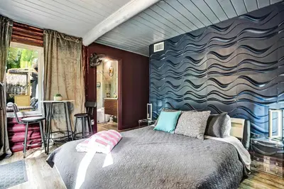 a bedroom with a large bed with a blue wall at Kiki 3 - Men's Clothing optional Guest Houses in Fort Lauderdale