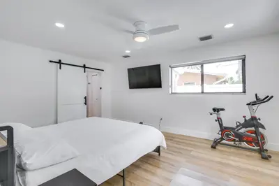 a bedroom with a bed and a exercise bike at Chic Florida Retreat with Pool, Patio and Gas Grill! in Fort Lauderdale