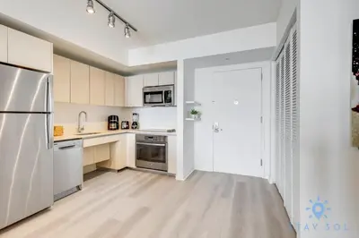 a kitchen with white cabinets and a stainless steel refrigerator at Amaizing Pool Infinity View w Balcony Gym in Hallandale Beach