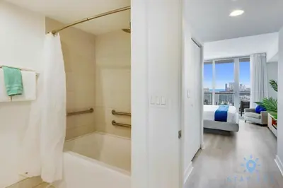 a bathroom with a bath tub and a bedroom at Amaizing Pool Infinity View w Balcony Gym in Hallandale Beach