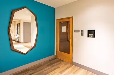 a hallway with a mirror on a blue wall at Stunning Apartment in Downtown Doral in Miami
