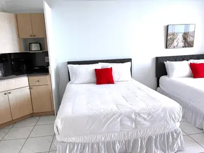 a bedroom with two beds with red pillows at Castle 1527 Studio Balcony Direct Beach Access, Pool, Tennis, Free Parking in Miami Beach