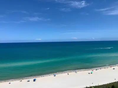 a beach with a group of people and the ocean at Castle 1527 Studio Balcony Direct Beach Access, Pool, Tennis, Free Parking in Miami Beach