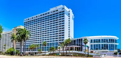 a large building with palm trees in front of it at Castle 1527 Studio Balcony Direct Beach Access, Pool, Tennis, Free Parking in Miami Beach