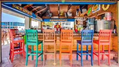 a group of colorful chairs sitting at a bar at Castle B6 in Miami Beach