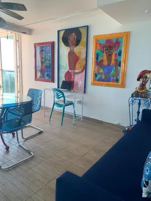a room with chairs and paintings on the wall at Castle BTH2 Stunning Oceanfront Townhouse, Private Beach Access, Private Pool Access, Tennis and Free Parking! in Miami Beach