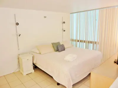 a bedroom with a white bed and a window at Castle M4 Beachfront Balcony Loft, FREE Parking, Pool, Tennis, Beach Access in Miami Beach