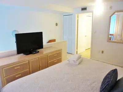 a bedroom with a bed and a television on a dresser at Castle M4 Beachfront Balcony Loft, FREE Parking, Pool, Tennis, Beach Access in Miami Beach