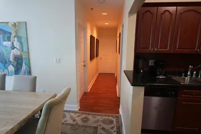 a kitchen with a table and a hallway with a hallway at Castle PH15 Spacious Penthouse with Balcony, Beach Access, Pool, Tennis, Free Parking in Miami Beach