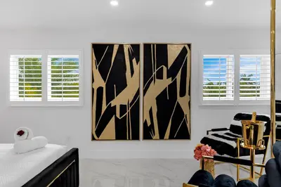 a white room with two windows and a chair at MIA MANSION W/ POOL / BBQ /CABANNA / OUTDOOR BAR in Tamiami