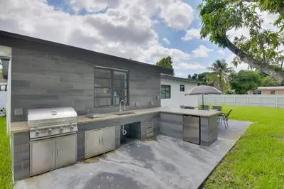 an outdoor kitchen with a sink and a stove at Luxe Miami Home Outdoor Kitchen, Gas Grill! in Miami Gardens