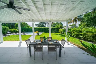 a table and chairs under a white pergola at New Tropical Oasis Retreat in Miami in Miami