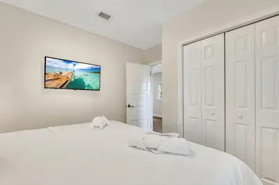 a white bedroom with a white bed and a tv on the wall at Casa Del Rio 4 Bed 2 Bath Next to River 1826 in Miami