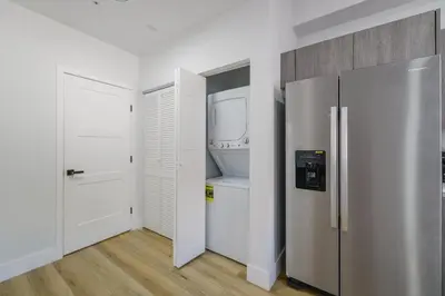 a kitchen with white walls and a refrigerator at Charming Apt Near to Stadium LoanDepot Park in Miami