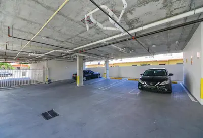 a parking lot with two cars parked in it at Charming Apt Near to Stadium LoanDepot Park in Miami