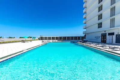 a swimming pool with chairs next to a building at Pavilion Residences on the Beach in Miami Beach