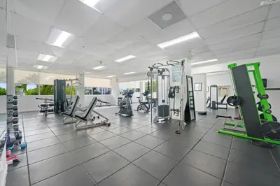 a gym with treadmills and machines in a room at Pavilion Residences on the Beach in Miami Beach