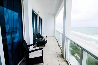 a balcony of a hotel with two chairs and a table at Castle Ph2 Balcony Oceanfront Condo, Beach Access, Pool, Tennis, Free Parking in Miami Beach