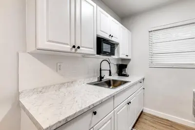 a white kitchen with a sink and white cabinets at Spacious 2 BR near Miami Airport Virg 5 in Miami